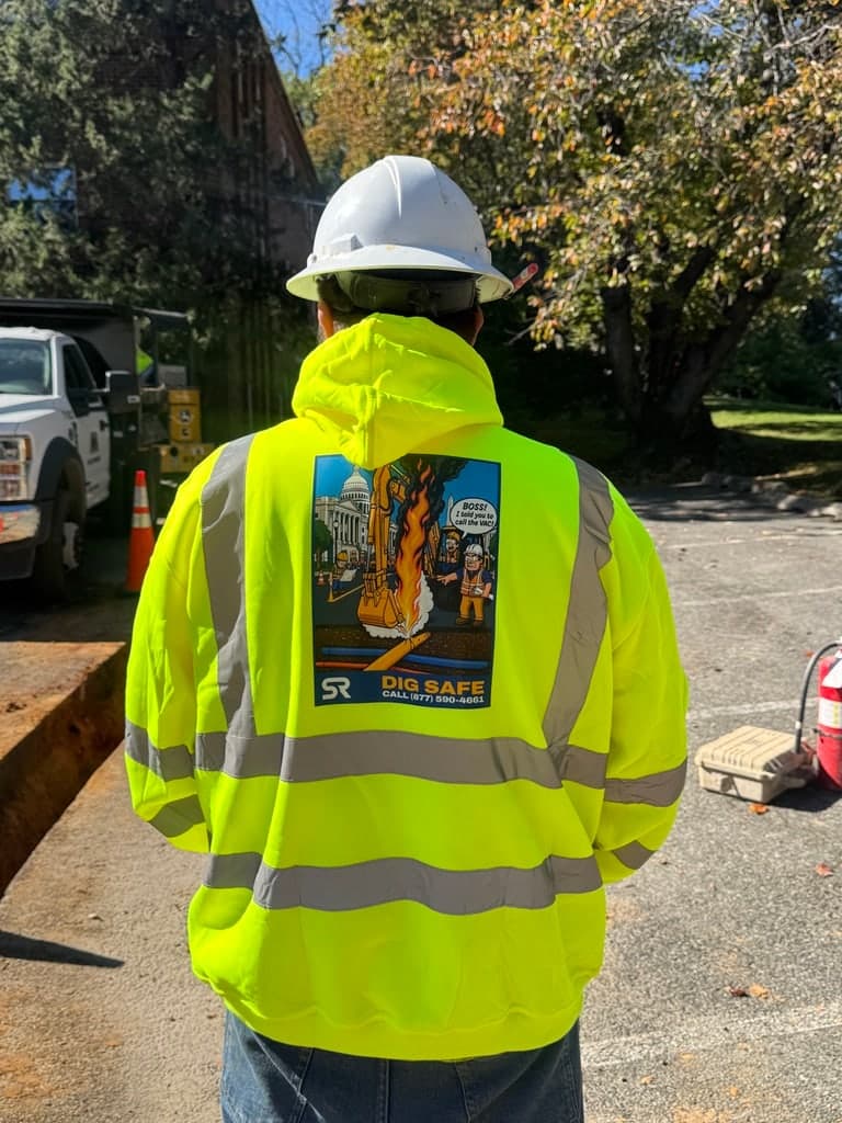SRVacJet crew member on a job site wearing the Dig Safe hi-vis hoodie