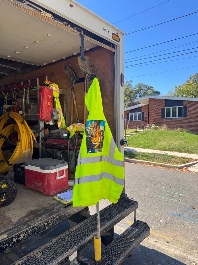 Dig Safe hoodie hanging on the back of an SRVacJet crew truck