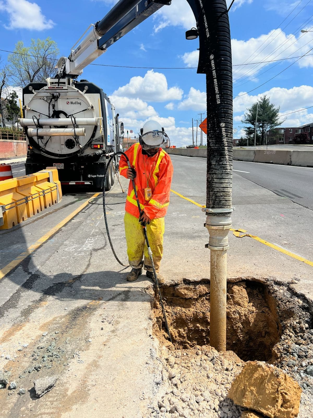 Hydro excavation test hole exposing buried utilities