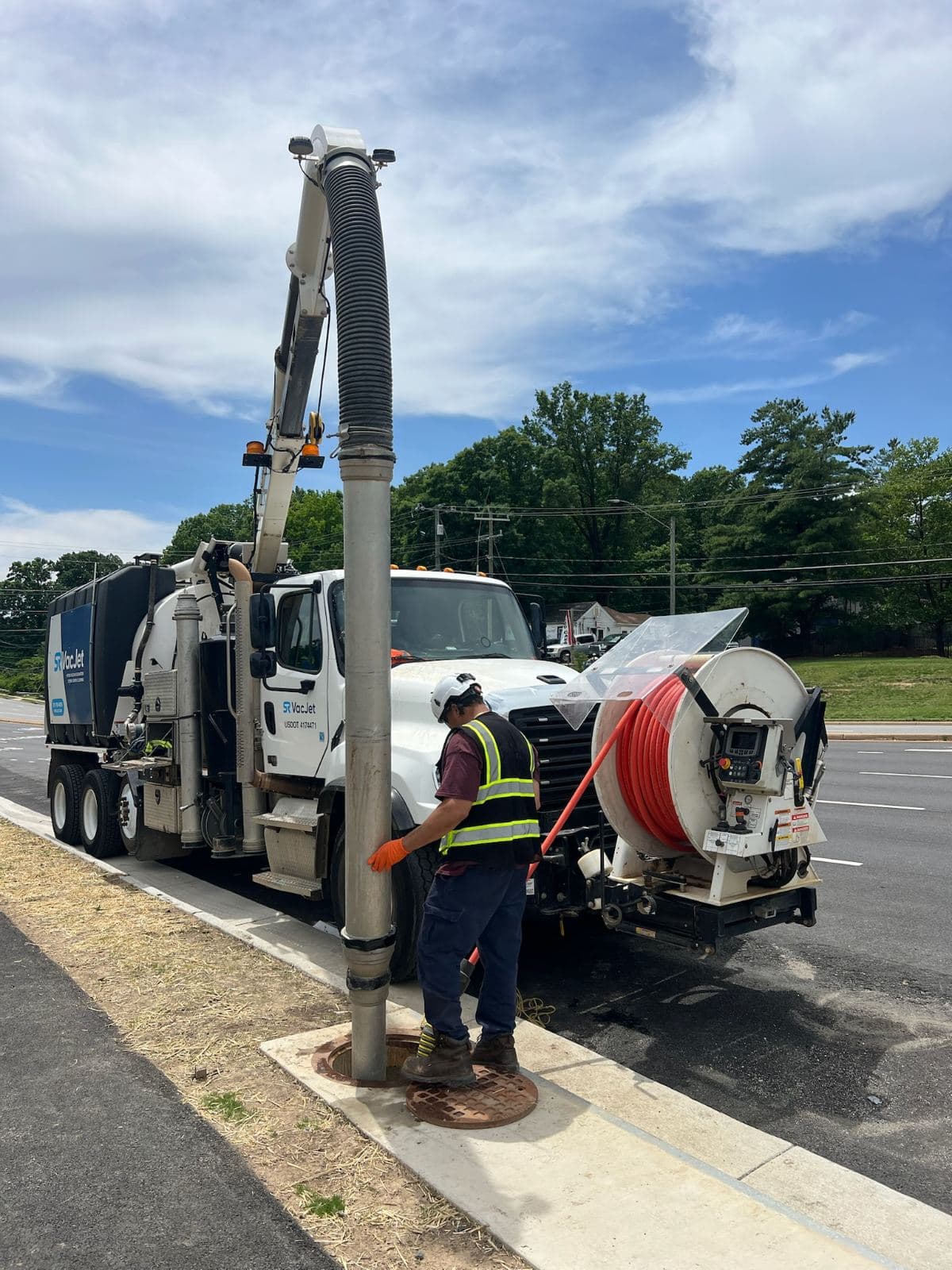 Jetter hose entering a roadside manhole